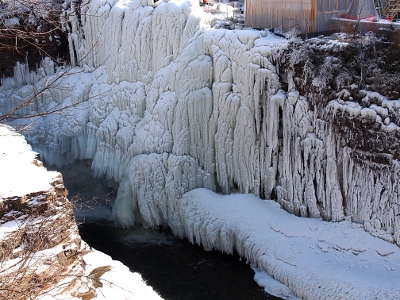 [An entire bank of several layers of icicles along the edge of the river.]